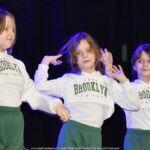 Trzy dziewczynki tańczące na scenie.