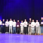 Nagrodzeni sportowcy i ich trenerzy pozują do zdjęcia.