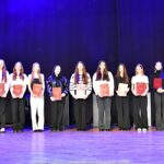 Nagrodzeni sportowcy i ich trenerzy pozują do zdjęcia.