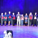 Nagrodzeni sportowcy i ich trenerzy pozują do zdjęcia.