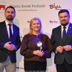 Nagrodzeni sportowcy i ich trenerzy pozują do zdjęcia.