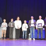 Nagrodzeni sportowcy i ich trenerzy pozują do zdjęcia.