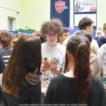 Wystawcy, młodzież i goście podczas prezentacji w liceum.