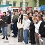 Wystawcy, młodzież i goście podczas prezentacji w liceum.