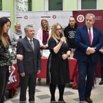 Wystawcy, młodzież i goście podczas prezentacji w liceum.