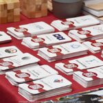 Wystawcy, młodzież i goście podczas prezentacji w liceum.