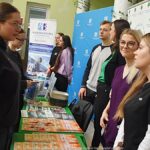 Wystawcy, młodzież i goście podczas prezentacji w liceum.