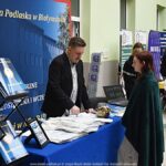 Wystawcy, młodzież i goście podczas prezentacji w liceum.