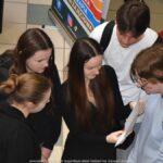 Wystawcy, młodzież i goście podczas prezentacji w liceum.