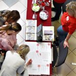 Wystawcy, młodzież i goście podczas prezentacji w liceum.