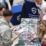 Wystawcy, młodzież i goście podczas prezentacji w liceum.