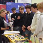 Wystawcy, młodzież i goście podczas prezentacji w liceum.