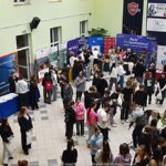 Wystawcy, młodzież i goście podczas prezentacji w liceum.