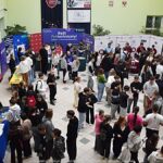 Wystawcy, młodzież i goście podczas prezentacji w liceum.