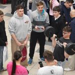 Wystawcy, młodzież i goście podczas prezentacji w liceum.