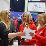 Wystawcy, młodzież i goście podczas prezentacji w liceum.