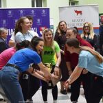 Wystawcy, młodzież i goście podczas prezentacji w liceum.