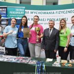 Wystawcy, młodzież i goście podczas prezentacji w liceum.