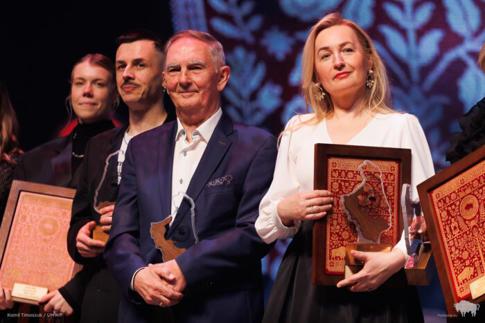 Cztery osoby stoją na scenie filharmonii i pozują do zdjęcia. Po bokach dwie kobiety, w środku dwóch mężczyzn.