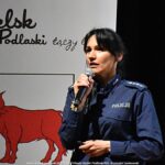 Policjantka przemawiająca do mikrofonu.