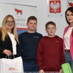 Grupowe zdjęcie nagrodzonych dzieci i nauczycieli ze szkół, w towarzystwie urzędników.