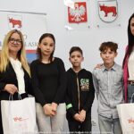 Grupowe zdjęcie nagrodzonych dzieci i nauczycieli ze szkół, w towarzystwie urzędników.