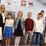 Grupowe zdjęcie nagrodzonych dzieci i nauczycieli ze szkół, w towarzystwie urzędników.