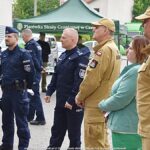 Grupa ludzi przed pojazdem ustawionym na Placu Ratuszowym.