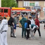 Grupa ludzi przed pojazdem ustawionym na Placu Ratuszowym.
