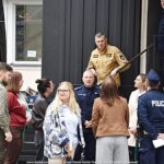 Grupa ludzi przed pojazdem ustawionym na Placu Ratuszowym.
