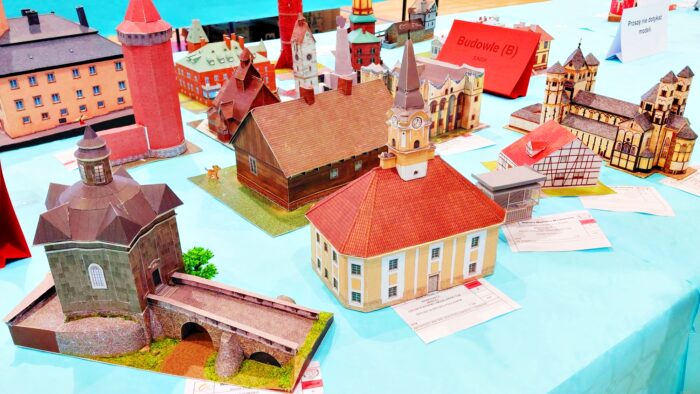 Wystawa prac modelarskich. Na długim stole wystawione miniatury budynków. W środku kadru - ratusz w Bielsku Podlaskim.