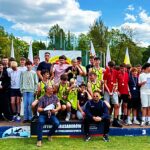 Grupa młodych sportowców na podium.