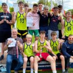 Grupa młodych sportowców na podium.