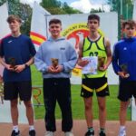 Grupa młodych sportowców na podium.