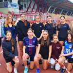 Grupa młodych sportsmenek na podium.