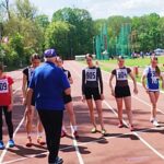 Grupa młodych sportsmenek na bieżni.