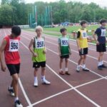 Grupa młodych sportowców na bieżni.