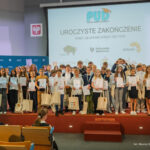 Uroczyste zakończenie roku akademickiego. Zdjęcie grupowe dzieci i dorosłych.