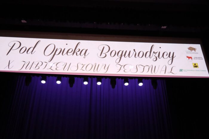Napis nad sceną: Pod Opieką Bogurodzicy".