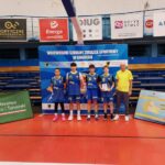 Zdjęcie drużyny koszykarskiej na hali sportowej.