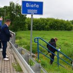 Ludzie schodzący w dolinę rzeki z mostu.