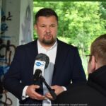 Burmistrz wypowiadający się do mikrofonu telewizyjnego.