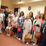 Wizyta artystów u burmistrza. Zdjęcie grupowe - kilkanaście osób uśmiecha się i pozuje do zdjęcia.