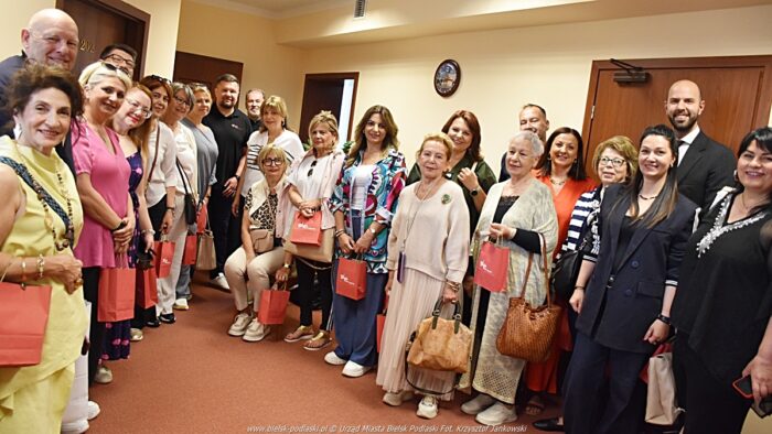Wizyta artystów u burmistrza. Zdjęcie grupowe - kilkanaście osób uśmiecha się i pozuje do zdjęcia.