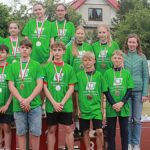 Młodzi lekkoatleci podczas zawodów i wręczania nagród.