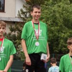 Młodzi lekkoatleci podczas zawodów i wręczania nagród.