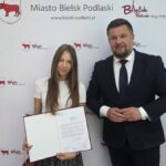 Burmistrz i radna pozują do zdjęcia.