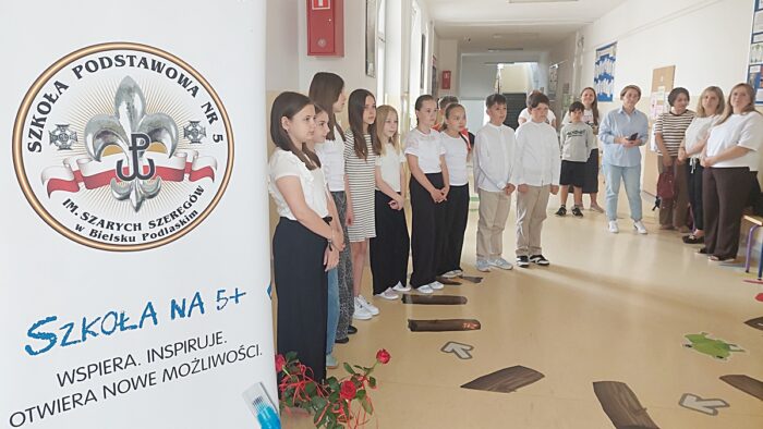 Uroczystość wręczenia nagród uczniom na korytarzu szkolnym.