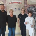 Uroczystość wręczenia nagród uczniom na korytarzu szkolnym.