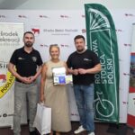 Zdjęcie uczestnika rywalizacji z Dyrektorem MOSiR i Burmistrzem Miasta Bielsk Podlaski na tle banerów